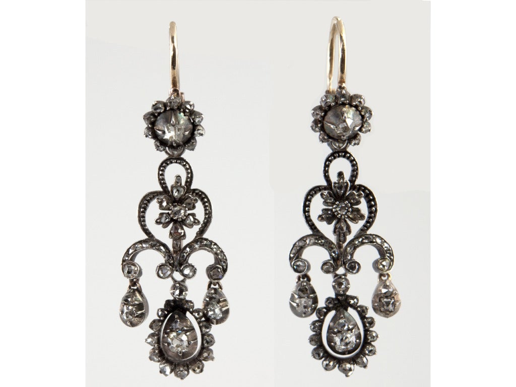 Silver and gold late 19th century earrings that transition from day to evening.  These Victorian earrings are filled with rose cut and mine cut diamonds. The top is a single flower of these diamonds that can be worn with or without the longer drop.