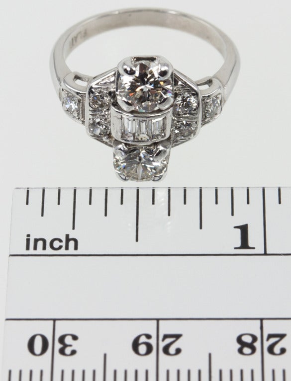 Platinum cocktail ring with two  approximately .60ct round brilliant diamonds approximately I-J color VS1 clarity at the top and bottom, with a section of 3 standing baguettes in between, and three full cuts on each side. This is a simple and