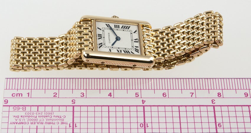 18k yellow gold Cartier classic Tank wristwatch with an 18k yellow gold bracelet. This watch is circa 1980s and has a quartz movement.