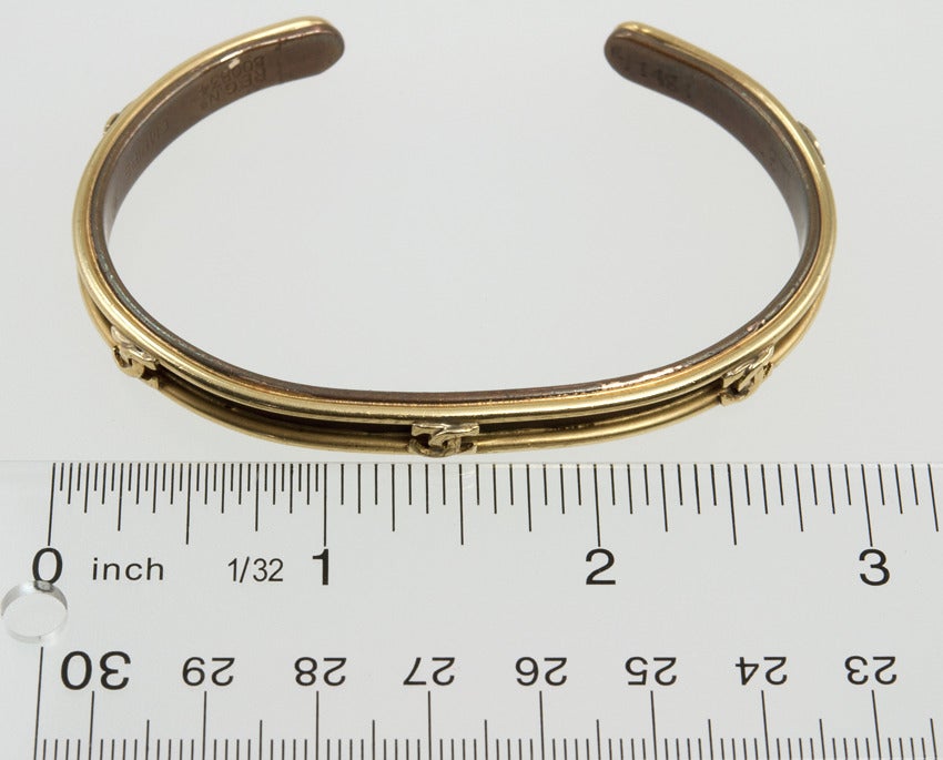 Made of 18k yellow gold and copper, this CARTIER cuff is on the larger side.  Most likely made for a man, it has the signature interlocking 