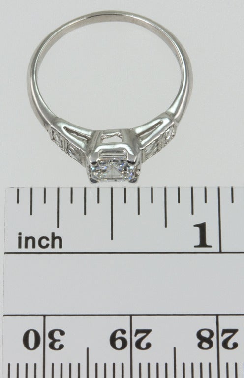 Platinum ring with a center .70 carat Asscher cut diamond. It is D color SI2 clarity with an EGL certificate.  The sides have two small horizontal baguette diamonds and one vertical, all with beautiful mill grained accents. Very elegant.
* This