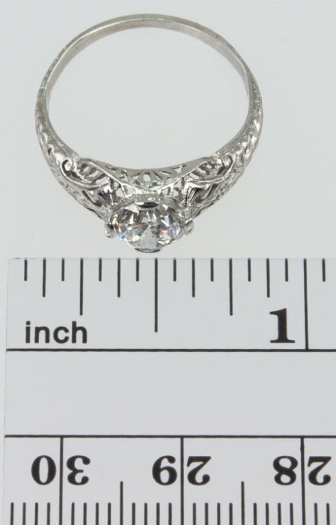 Platinum highly filagreed ring with a center old european cut diamond 1.05 carats D-SI2 with an EGL certificate.  Although there are no additional diamonds in the hunting, it has so much beautiful work and engraving, it doesn't need it! 
* This