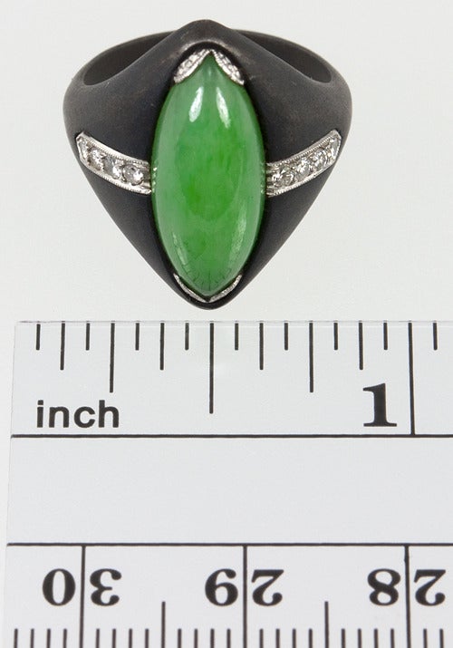Art Deco at its finest.  This ring is Jade and Diamond set into 18 karat white gold set into blackened steel.  It is unsigned yet unmistakably Marsh & Co.
It is size 5 and cannot be altered.

*This would pair beautifully with Lang's Marsh