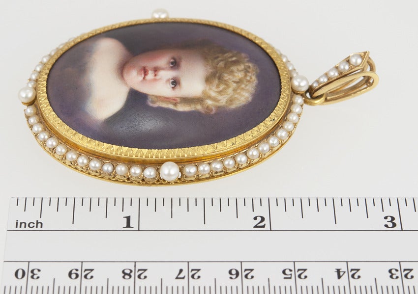 What a baby!  This child's portrait is painted in incredible detail on Mother of Pearl in an 18 karat yellow gold seed pearl frame.