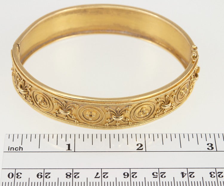 Beautifully adorned 22 karat yellow gold Etruscan Revival style Bangle bracelet with Portuguese hallmarks.  It is 15mm wide and measures 20 centimeters around the inside.