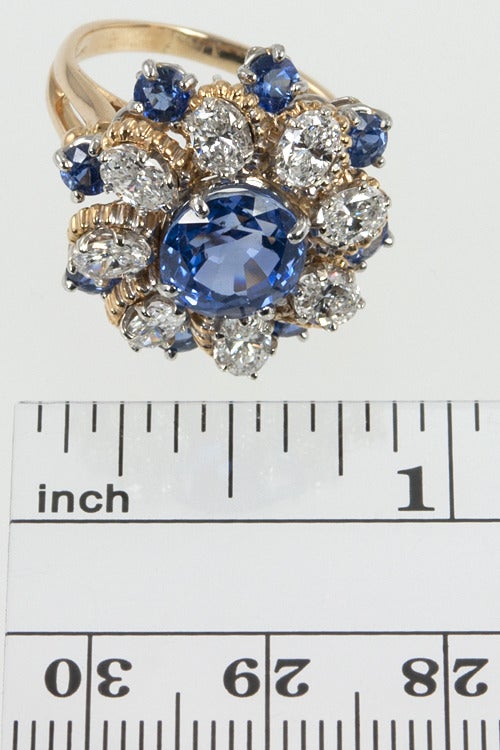 Oscar Heyman makes exceptional jewelry!  The center is an approximately 2 carat natural sapphire with 8 oval diamonds, 2 carats in 18 karat yellow.  Size 6  and easily altered.  
Gorgeous!