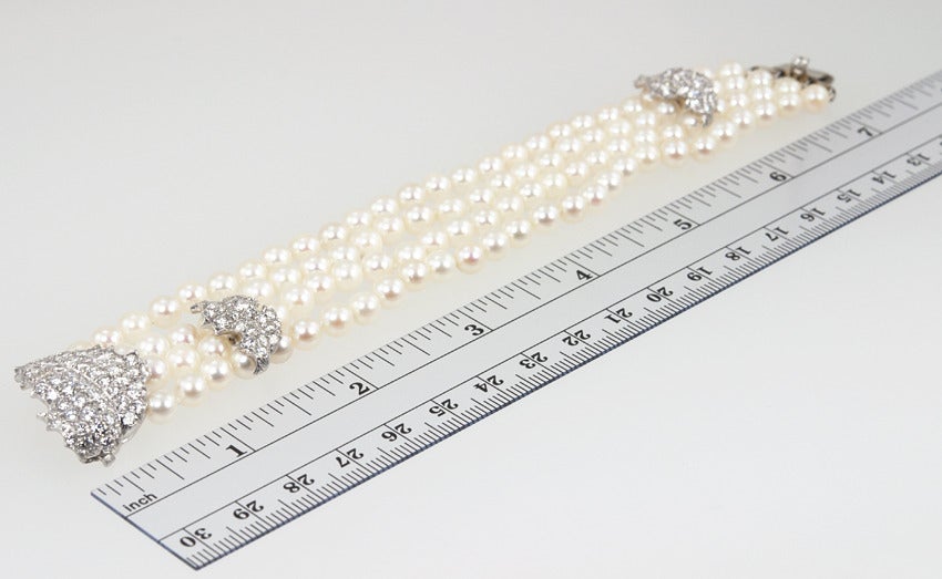 Beautiful Ruser signed cultured pearl (5 1/2-6mm) and diamond bracelet and matching leaf brooch.  6 carats of white clean diamonds. Set in platinum with an 18k gold clasp.  Signed on the bracelet and again on the leaf brooch.