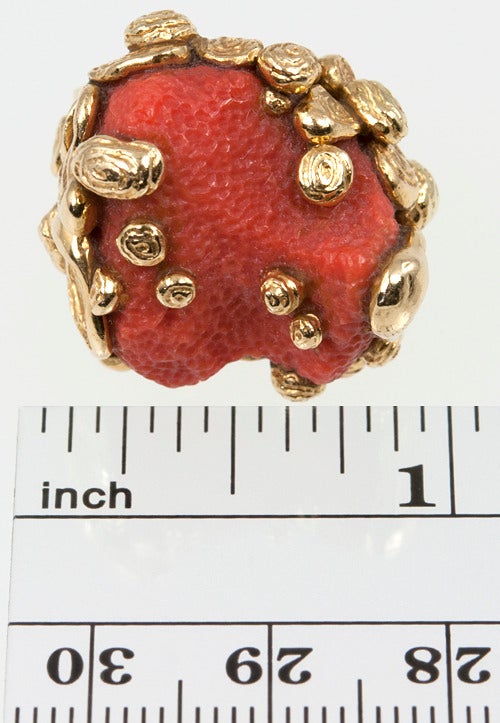 Cartier stepped up the design for this Coral ring.  The coral is carved in a beautiful dimpled pattern and pools of molten gold are floating on the coral.  18 karat yellow gold.  Size 5 1/2 and easily sized. Numbered and signed Cartier.