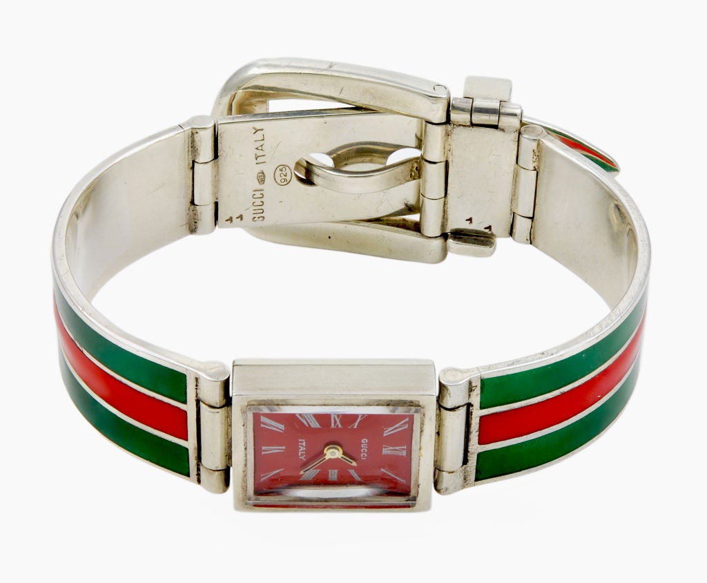A rare Gucci red and green enamel buckle bracelet watch.  Watch is in working order and keeps good time.  It is a manual movement.  Fits up to a 7
