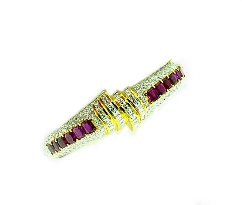 This is a dazzling designer bracelet by GUCCI. . .featuring pave' diamonds and a center row of bright red rubies. This amazing bracelet has a side hinge.