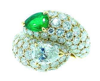 This is an incredibly gorgeous designer ring by CARTIER. . .an emerald and diamond bypass ring.
This stunning ring features a pear-shaped emerald and a pear-shaped diamond . . with pave' diamonds surrounding them.
The ring is absolutely 