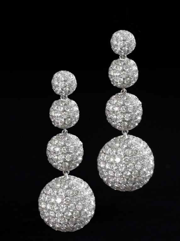 13 cts of well matched white diamnds are paved in these sphere shaped hanging earrings