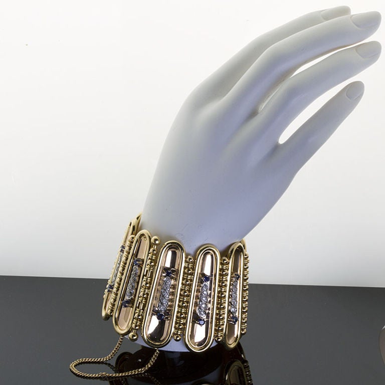 A unique wide 18k yellow and rose gold articulating cuff with diamond & sapphire accents in the style of Egyptian adornments.
144 gr

Dealer ref No. 2920