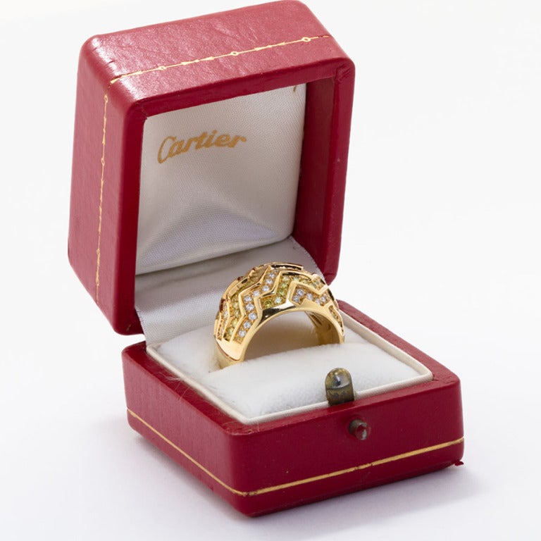 Fancy yellow and white diamonds in a zig-zag pattern channel set in 18 karat yellow gold dome ring by Cartier. In signature Cartier box.

No. 3686