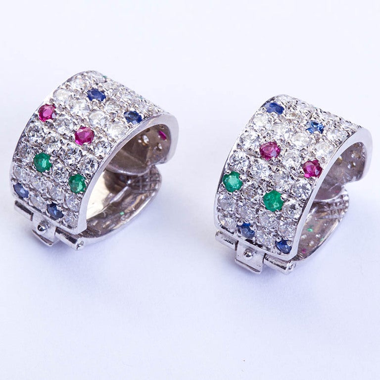 A pair of white gold domed earrings set with diamonds, sapphires, emeralds, and rubies by Van Cleef & Arpels contains ~2.15cts of diamonds. Signed and numbered with certificate of authenticity. Measures 1.5cm high, 0.9cm wide

Dealer ref. 4130