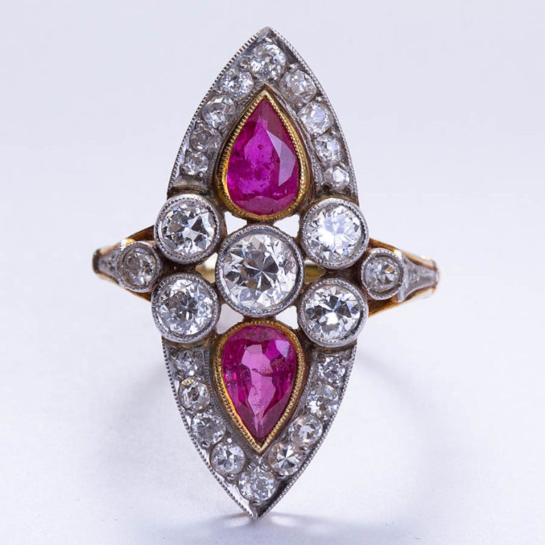 Antique cocktail ring with diamonds and two pear shaped rubies.  ~1.10 carats of natural ruby, ~2.20 carats of old cut round diamonds. Edwardian styling throughout.
1-3/16