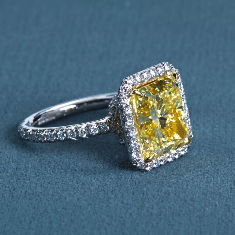 A very fine square radiant mixed-cut fancy yellow center diamond set in a fine diamond pavé platinum and 18k gold ring. Center diamond is accompanied by a GIA report stating it to be a 6.06 carat Natural Fancy Yellow VS1 clarity.