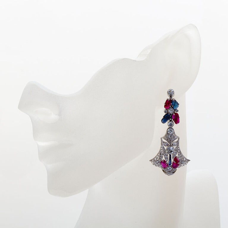 Red white and blue - and Tutti Frutti, too! Carved rubies and sapphires are the fruit that grace this exquisite pair of dangle earrings in the style made famous by Cartier. Very fine French style craftsmanship with pavé-set diamond filigree and