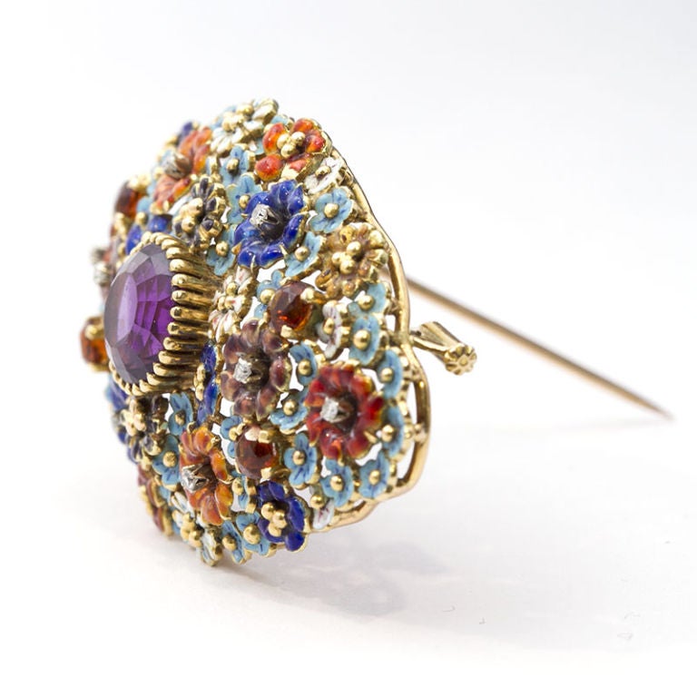 A whimsical and vibrant flower bouquet brooch made of 18k gold and enamel with a large amethyst center stone and diamond accents.

No. TMWJ-2576
SRP: $5,000
