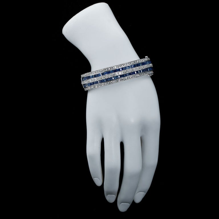 Deux valent mieux qu'un.  Two are better than one. 
A pair of original authentic Art Deco platinum bangles with old cut round diamonds and square step cut sapphires as a striped five-line design. Contains approximately 30 ctw of diamonds and 35 ctw