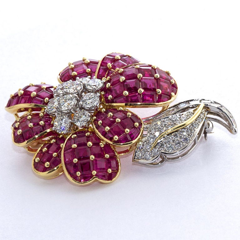 Diamond and ruby flower brooch of 18k yellow gold and platinum by Oscar Heyman. Contains aprox. 13.00 carats of rubies and aprox. 3.70 carats of diamonds.

Dealer ref. 1527