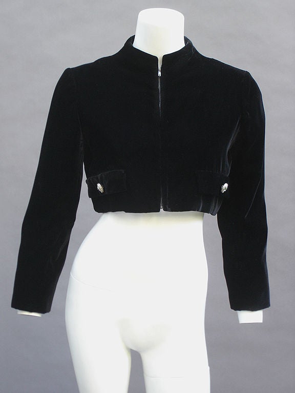 Ultra-chic black velvet bolero jacket from the 1940s. Lusciously soft velvet. Slim fit. Oversized rhinestone buttons on faux pockets. Mandarin collar. Lined in ivory grosgrain. Dripping amazing quality from every inch!

SIZE 6
BUST 34
SLEEVES