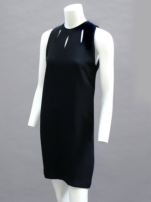 Simple black shift dress by Gianni Versace with three cut-outs at neckline. A classic 60s-inspired silhouette. Super easy to wear. Skims the body rather than hugging it. Transitions from office to dinner date perfectly. Back zipper and unlined. In