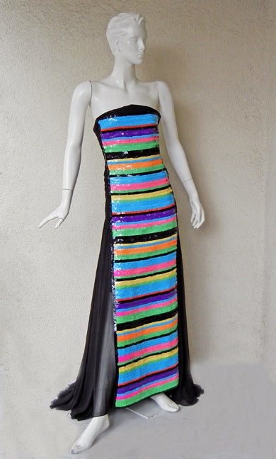 Rare Chanel strapless gown designed in horizontal rows of multi color handsewn pailletes from top to bottom. Features corset bodice extending into a short sheath and overlayed in layers of back silk chiffon. 

Full swantail train with ruched back.