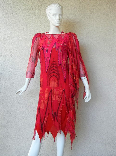 Important Zandra Rhodes 1985 New York City landmark collection featuring the Empire State and Chrysler Buildings.

Dress fashioned in the designer's signature silk chiffon with matching jersey underslip. Single shoulder overlay drape. Beaded