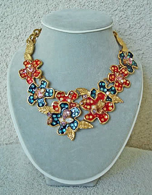 Christian Lacroix 24 kt gold wash gilded flower necklace circa 1990's. Large flower clusters of red and blue enamel sprinkled with clear crystals and accented by gold leaves. 

Necklace measures approx 17