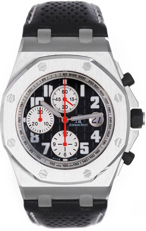 Automatic winding chronograph wristwatch. Stainless Steel case. Black dial with white Arabic numerals and white sub-dials; date at 3 o'clock.  Black strap band with white stitching and stainless steel deployant clasp.  Unused with Audemars Piguet