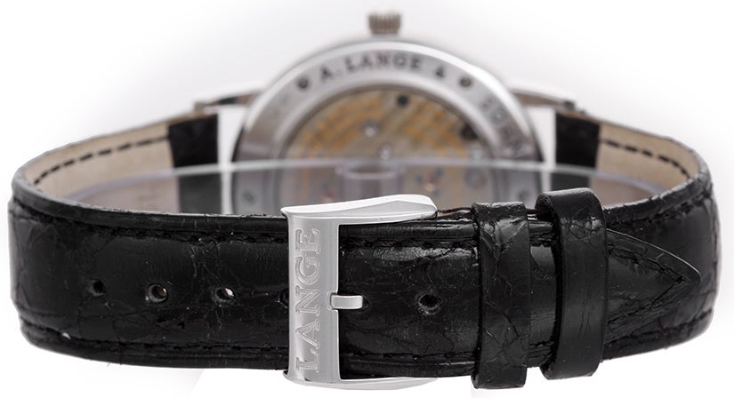 A. Lange & Sohne platinum 1815 wristwatch, Ref. 206.025, with manual-wind movement. Platinum case with exhibition back (40mm diameter). Silvered dial with Arabic numerals, subsidiary seconds. Black croc strap band with platinum Lange buckle.