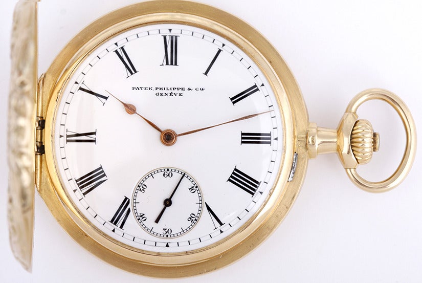 Patek Philippe 18k yellow gold repousse hunter case pocket watch, with manual-wind movement, cal. 18''' nickel-finished lever movement. 18k yellow gold repousse hunter case with floral and swag design to the front cover back with raised plaque (48mm