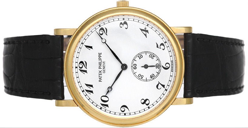 Automatic winding. 18k yellow gold case (33mm diameter). White dial with black Roman numerals; subseconds at 6 o'clock. Strap band with 18k yellow gold Patek Philippe buckle. Pre-owned with Patek Philippe box and papers.