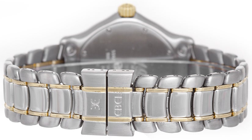 Quartz movement. Stainless steel case with 18k yellow gold bezel, 38mm diameter. White dial with gold Roman numerals, date at 3 o'clock. Stainless steel and 18k yellow gold Ebel bracelet with deployant clasp. Pre-owned.
