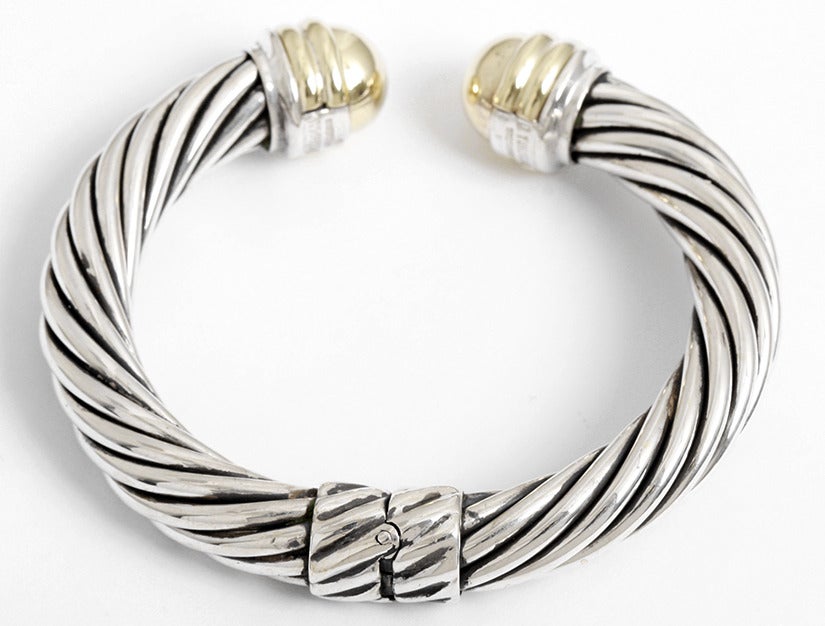 This is a beautiful and classic David Yurman 14k yellow gold and sterling silver cable bracelet. The cable is apx. 10 mm wide with a hinge opening. The total weight is 43.6 grams.