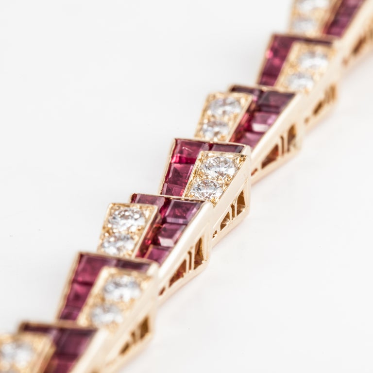 This contemporary bracelet by Oscar Heyman & Brothers features 70 square-cut rubies weighing 11.20 carats total and 42 F-G color, VVS clarity round brilliant-cut diamonds weighing 2.83 carats total. The 18 karat yellow gold bracelet is 7