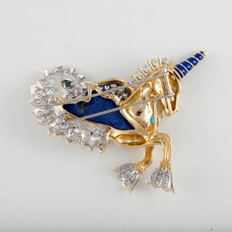 This Cartier brooch features 4.7 carats of round brilliant-cut diamonds to compliment the turquoise and lapis. Set in 18k yellow gold, this brooch is a unique and whimsical piece. Signed Cartier.