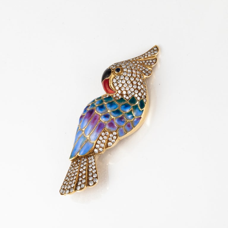Charming 18kt yellow gold parrot pin with 3.60 carats total weight diamonds, red and black enamel on the beak, and plique a jour enameled wings.