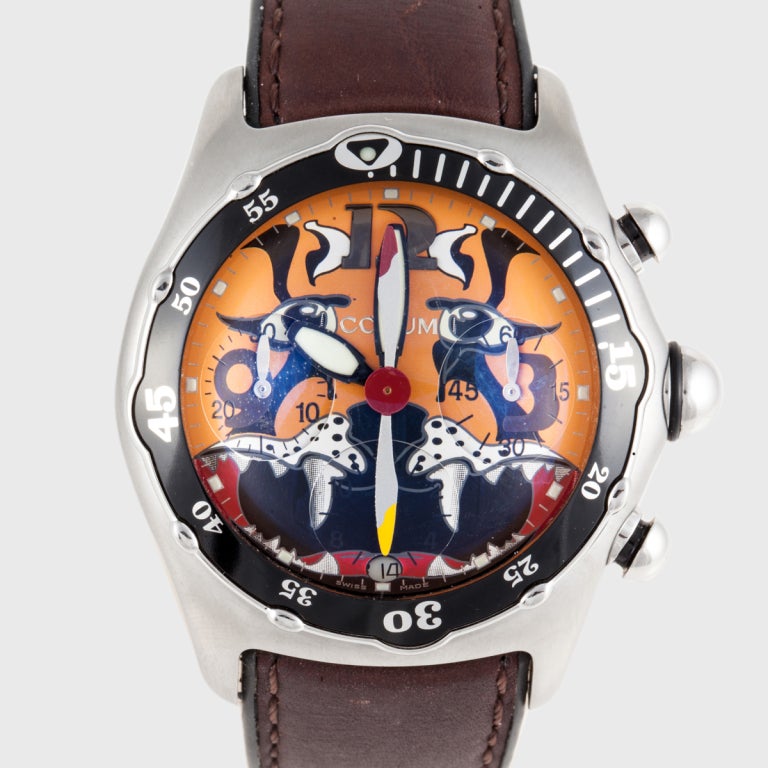 This Corum Dive Bomber watch is a limited edition chronograph. It features a bubble crystal and a rotating bezel. The watch is stainless steel and has a brown leather band.