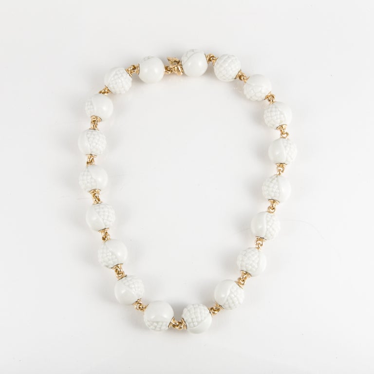 This Bulgari necklace is 18k yellow gold, with white porcelain beads. The beads are textured on one side and smooth on the other, creating a beautiful contrast. The necklace is 17