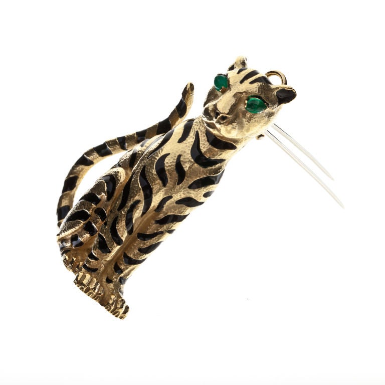 David Webb tiger brooch in 18K yellow gold with black enamel stripes and cabochon emerald eyes.  The emeralds total 0.40 carats.  Measures 2 3/8 inches long,  1 3/4 inches wide and 1/2 inch deep.