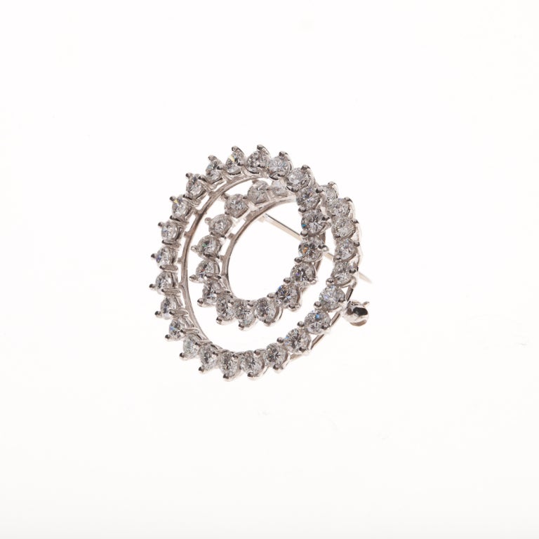 Tiffany & Co. circular pin composed of platinum and round brilliant-cut diamonds.  The diamonds total 4.10 carats, E-F color, VVS2-VS1 clarity.  Signed:  Tiffany & Co Irid Plat