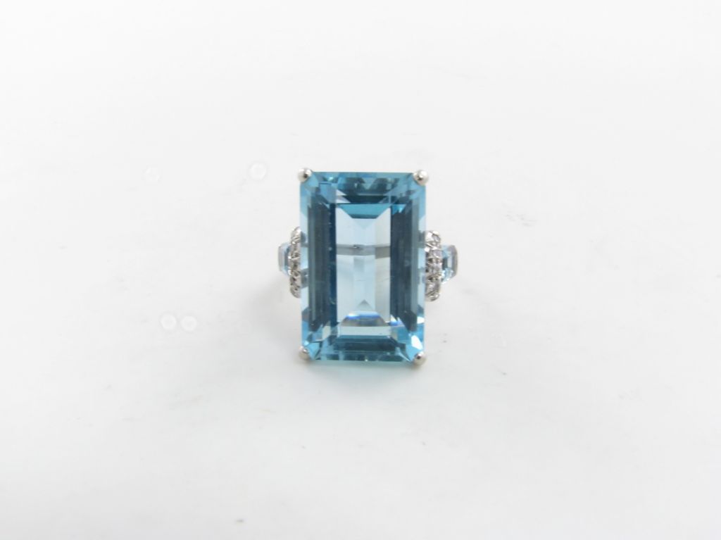 An 18 karat white gold, aquamarine and diamond ring.  The ring centers a 19.00 carat emerald cut aquamarine surrounded by diamonds and aquamarines.  Size 8.