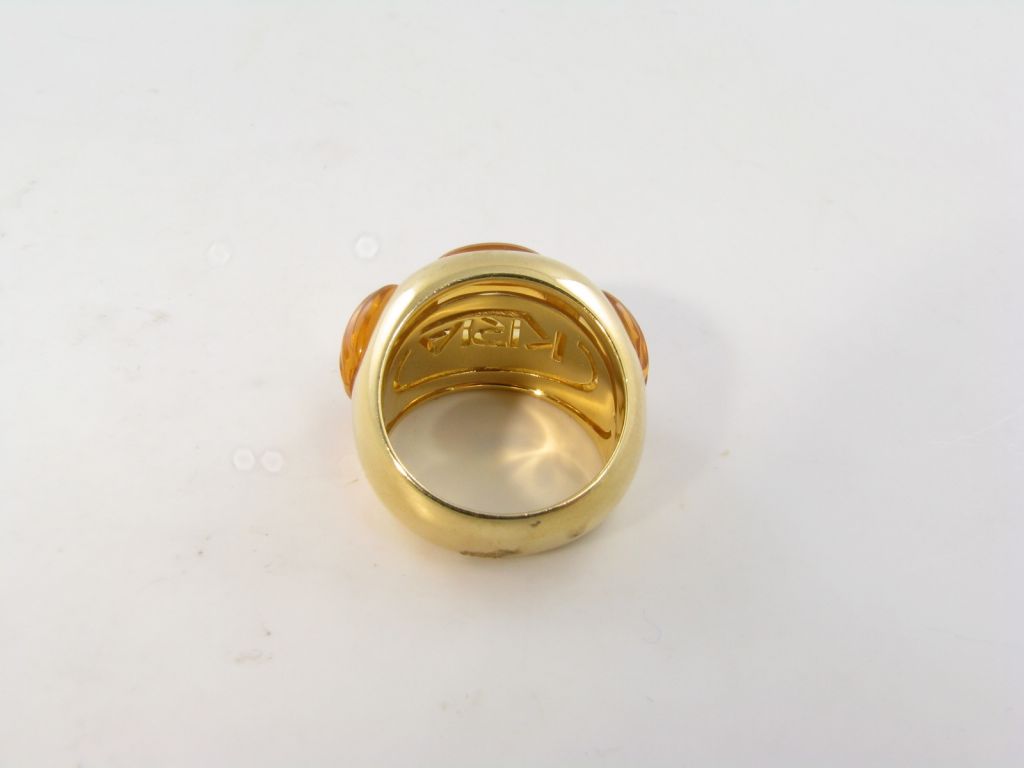 An 18 karat yellow gold and citrine ring.  Kria.  The ring is set with three fluted citrine cabochons with an approximate gross weight of 18.2 grams.