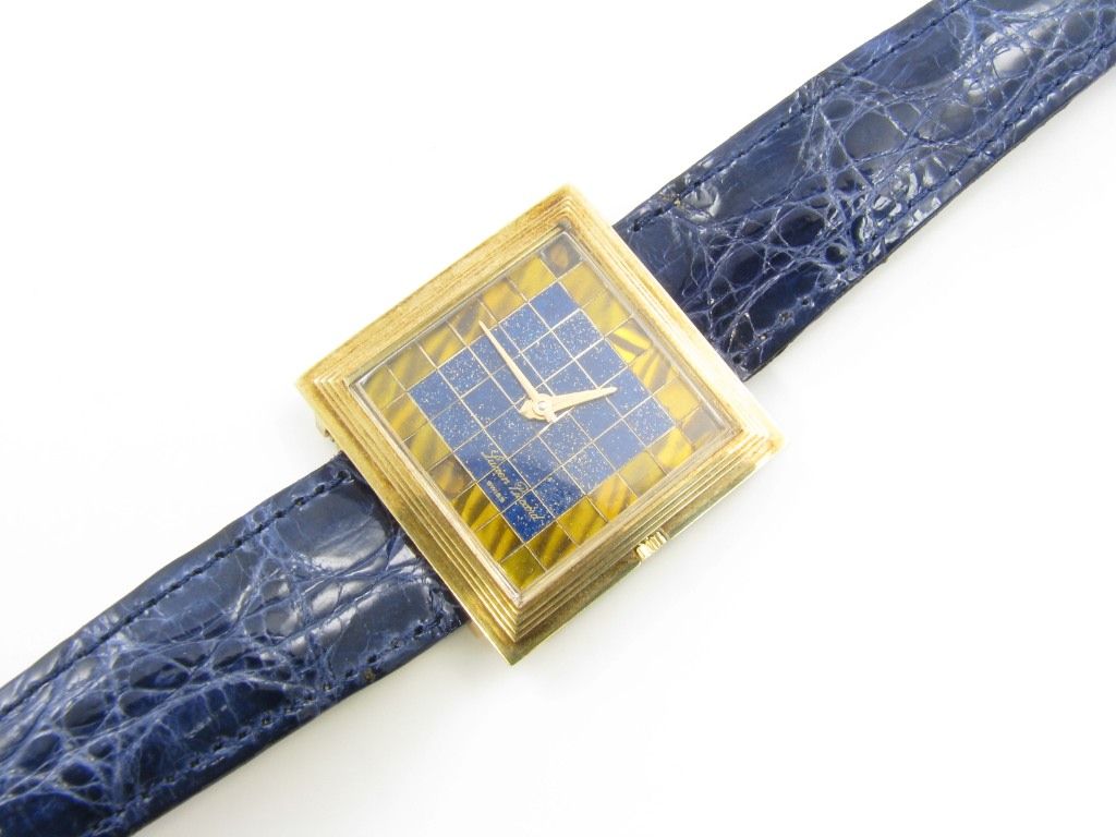 A 14 karat yellow gold Lucien Piccard watch designed with a lapis and tiger’s eye square shaped dial.
