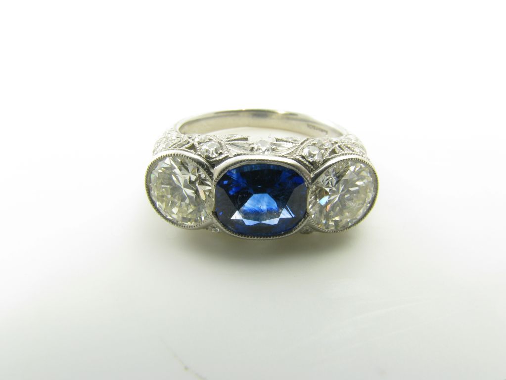 An exquisite Art Deco platinum, sapphire and diamond three stone ring. Tiffany & Co. Center sapphire weighs approximately 2.00 carats, flanked by two diamonds totaling approximately 2.00 carats.