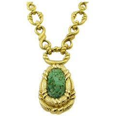A chic gold and carved jade pendant necklace.