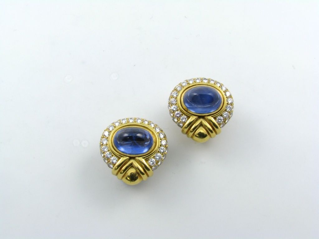 A pair of 18 karat yellow gold, sapphire and diamond earrings.  Bulgari.  The earrings are set with a total of (82) eighty two circular shaped diamonds totaling approximately 4.00 carats and (2) two sugar loaf cabochon sapphires totaling