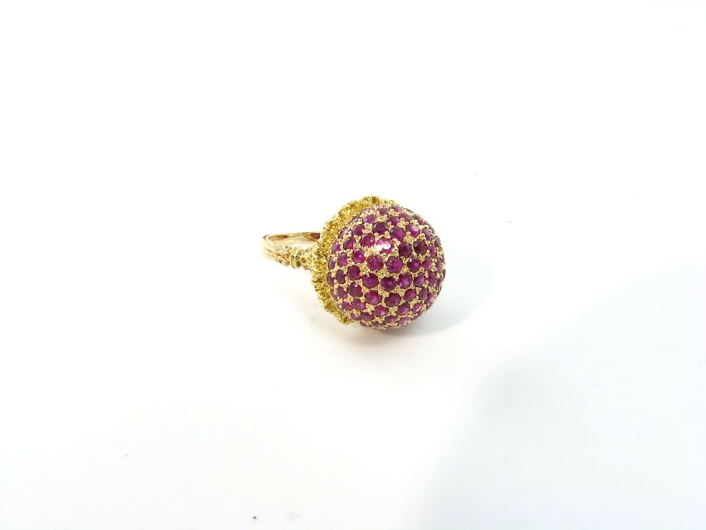 An 18 karat rose and yellow gold ring, with rubies in a bombe style.  Signed Buccellati.  Approximate weight of ring is 7.2 grams.
